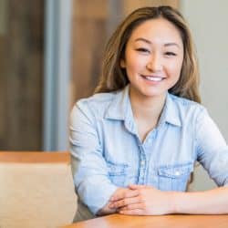 professional woman sitting at desk in office smiling
