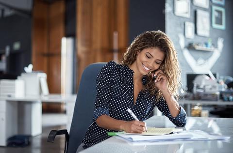 Woman sitting at a desk working on a resume