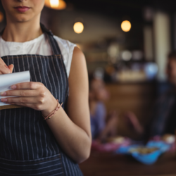 young waitress in a restaurant taking an order on a notepad