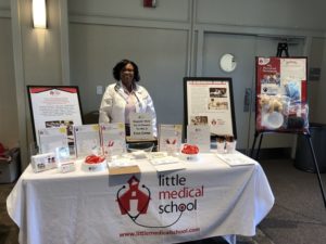 LMS's Keena standing behind resource table  smiling