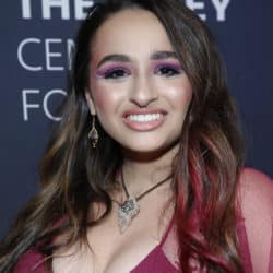 Jazz Jennings smiling while wearing a hot pink tank top dress