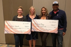 two women being presented with a giant check